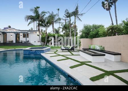 Une cour arrière avec une piscine et une pelouse herbeuse dans une nouvelle maison de construction moderne à Los Angeles Banque D'Images