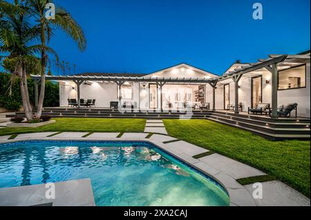 Une cour arrière avec une piscine et une pelouse herbeuse dans une nouvelle maison de construction moderne à Los Angeles Banque D'Images