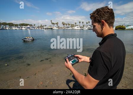 Un robot collecteur de déchets flottant navigue à Huntington Beach, CA. Contrôlé à distance par un logiciel autonome, l'appareil collecte les déchets flottants et har Banque D'Images