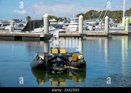 Un robot collecteur de déchets flottant navigue à Huntington Beach, CA. Contrôlé à distance par un logiciel autonome, l'appareil collecte les déchets flottants et har Banque D'Images
