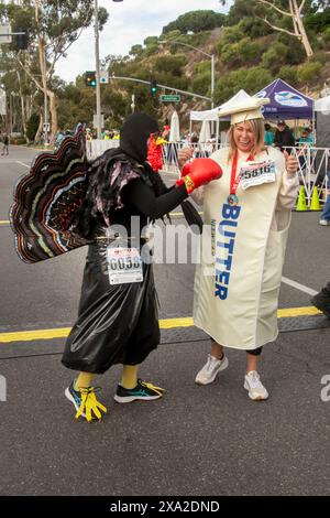 Une dinde avec des gants de boxe « luttant pour sa vie » rejoint un bâton de beurre dans un concours de costumes lors d'un événement de Thanksgiving « Turkey Trot » à Dana point, Banque D'Images