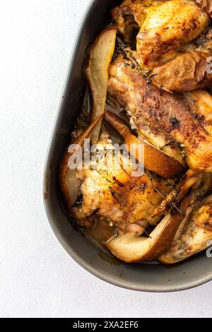Poulet cuit au four avec poires et thym, plat ovale avec morceaux de poulet cuits au four Banque D'Images