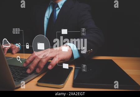 Homme d'affaires à l'aide d'un ordinateur pour la gestion de documents, document Management System (DMS) étant mis en place par un consultant INFORMATIQUE travaillant sur un ordinateur portable dans offic Banque D'Images