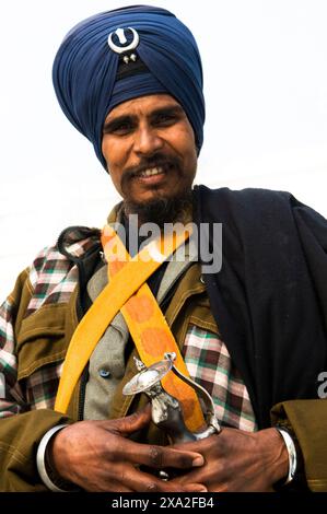 Un Sikh Nihang assis près de l'étang du Temple d'Or à Amritsar, Punjab, Inde. Banque D'Images