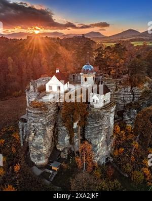 Sloup v Cechach, République tchèque - vue aérienne du château de Rock Sloup en Bohême du Nord avec un coucher de soleil coloré spectaculaire, nuages, ciel bleu et automne fo Banque D'Images