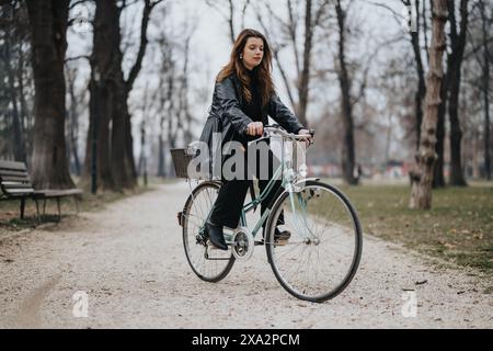 Femme d'affaires élégante chevauchant un vélo dans un cadre de parc, mettant en valeur la confiance et le style Banque D'Images