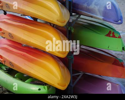 Les kayaks colorés sont empilés les uns sur les autres et stockés sur une plage, Baltrum Allemagne Banque D'Images