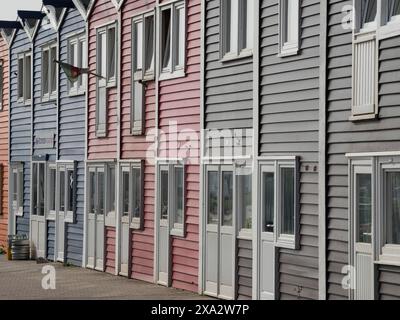 Bâtiments enfilés de couleur pastel, y compris gris, rose et bleu, atmosphère urbaine chaleureuse, Helgoland, Allemagne Banque D'Images