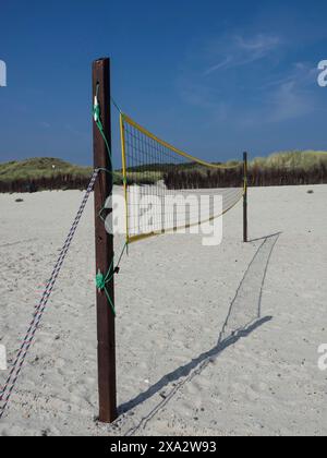 Un filet de volley-ball est installé dans le sable sur la plage, entouré de dunes et d'herbe, Heligoland, Allemagne Banque D'Images