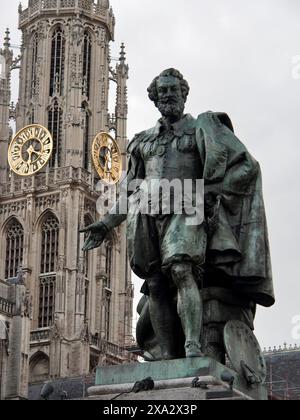Statue de bronze devant une tour historique avec des horloges sous un ciel nuageux, bâtiments historiques sur la place du marché à Anvers, Anvers, Belgique Banque D'Images