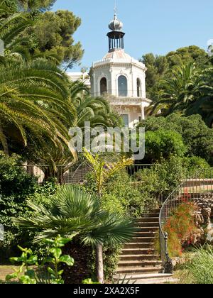 Une magnifique villa entourée de jardins luxuriants et de palmiers sous un ciel dégagé, la seyne sur mer, france Banque D'Images