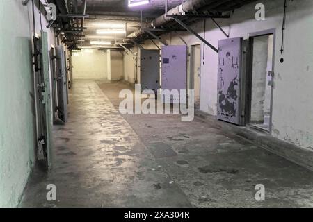 Long couloir dans une prison avec portes métalliques ouvertes et murs sales. Froid et désert, Mémorial Berlin-Hohenschoenhausen, ancien quartier général, Stasi Banque D'Images