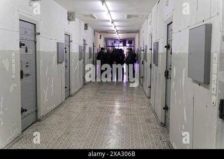 Groupe de personnes dans le couloir d'une prison avec portes grises et éclairage au néon, Berlin-Hohenschoenhausen Memorial, ancien siège, Stasi Remand Banque D'Images