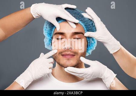Les mains du médecin en face de contrôle des gants de jeune homme Banque D'Images