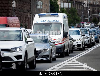 Non exclusif : KIEV, UKRAINE - 3 JUIN 2024 - une ambulance lutte contre la circulation dans la rue de Kiev, capitale de l'Ukraine. Banque D'Images