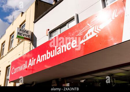 Un panneau au-dessus de la boutique de charité Cornwall Air Ambulance dans le centre-ville de Newquay en Cornouailles au Royaume-Uni. Banque D'Images