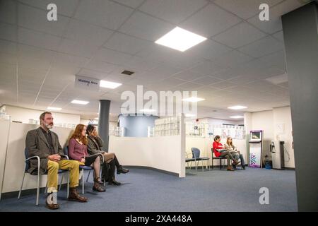 Les gens qui attendent dans une salle d'attente lumineuse d'un cabinet médical Banque D'Images