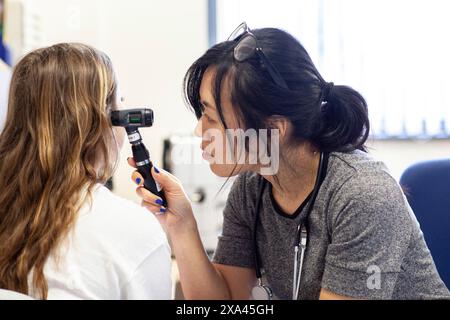 Médecin pratiquant un examen de l'oreille dans un cabinet médical Banque D'Images