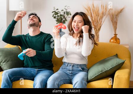 Couple jouant à un jeu vidéo et célébrant Banque D'Images