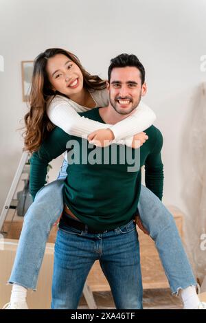 Homme donnant un tour de piggyback à la femme à l'intérieur Banque D'Images