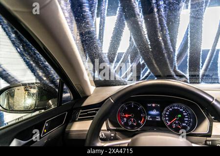 Voiture dans un lave-auto automatique, ligne de lavage de voiture, séchage, avec de l'air chaud et des tissus textiles rotatifs, Banque D'Images