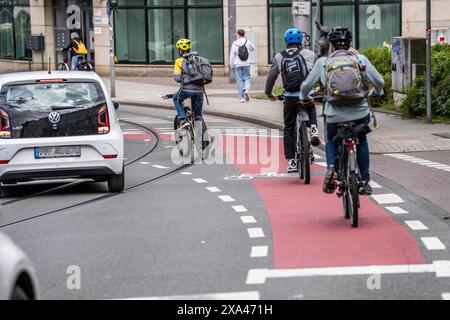 Cycliste dans le centre-ville, piste cyclable marquée en rouge, voitures roulent à proximité, Mülheim an der Ruhr, NRW, Allemagne, Banque D'Images