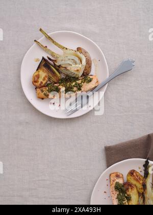 Vue d'en haut repas gastronomique de saumon grillé avec pesto, pommes de terre au four, fenouil et poireau Banque D'Images