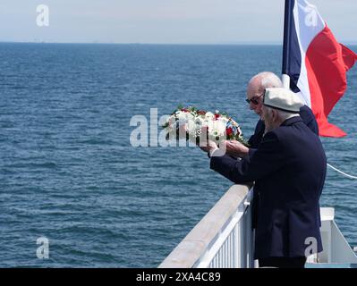 Les vétérans du jour J Harry Birdsall, 98 ans, et Alec Penstone (avant), 98 ans, jettent une couronne à la mer pendant le service de pose de couronnes du Spirit of Normandy Trust juste au large des côtes françaises, pour se souvenir de ceux qui n'ont jamais atteint le rivage, à bord du Mont St Michel. Le Brittany Ferries navigue du port de Portsmouth au Royaume-Uni à Ouistreham, à Caen, en France, transportant 31 vétérans du jour J et de la Normandie qui voyagent avec la Royal British Legion et Spirit of Normandy Trust pour participer aux commémorations marquant le 80e anniversaire du jour J. Date de la photo : mardi 4 juin 2024. Banque D'Images