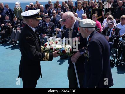 Les vétérans du jour J Harry Birdsall, 98 ans, et Alec Penstone (à droite), 98 ans, reçoivent la couronne pendant le service de pose de couronnes du Spirit of Normandy Trust juste au large des côtes françaises, pour se souvenir de ceux qui n'ont jamais atteint le rivage, à bord du Mont St Michel. Le Brittany Ferries navigue du port de Portsmouth au Royaume-Uni à Ouistreham, à Caen, en France, transportant 31 vétérans du jour J et de la Normandie qui voyagent avec la Royal British Legion et Spirit of Normandy Trust pour participer aux commémorations marquant le 80e anniversaire du jour J. Date de la photo : mardi 4 juin 2024. Banque D'Images