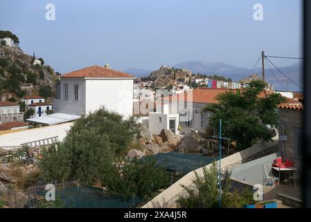 Il s'agit d'une vue panoramique d'une ville côtière méditerranéenne avec des bâtiments blancs, des toits en terre cuite, et un château perché au loin, sous un ciel bleu clair. Banque D'Images