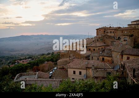 Vue sur le coucher du soleil sur une ancienne ville perchée avec des toits en terre cuite, entourée d'un paysage rural. Banque D'Images