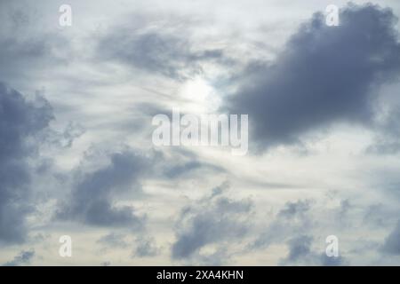 C'est une image sereine d'un ciel nuageux avec la lumière du soleil essayant de jeter un coup d'œil à travers les couches de nuages. Banque D'Images