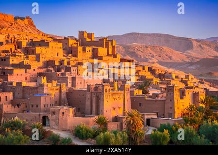 Ait-Benhaddou, Maroc. Exemple frappant d'architecture en argile et de kasbah en Afrique du Nord, chaîne de montagnes Atlas en arrière-plan. Banque D'Images