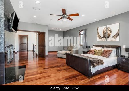 Élégante chambre principale au design bicolore, planchers de bois franc et murs gris Banque D'Images