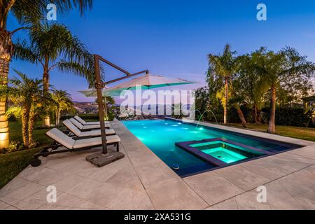 Un superbe espace piscine avec des chaises longues blanches immaculées Banque D'Images