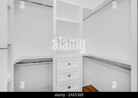Un placard blanc vacant avec des étagères, des armoires et un tiroir Banque D'Images