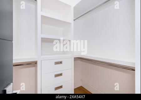 Un dressing spacieux avec parquet élégant et murs blancs immaculés Banque D'Images