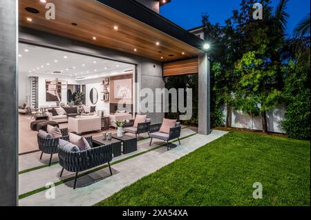 Un patio avec une table et une chaise spacieuses entourées d'herbe verte luxuriante Banque D'Images