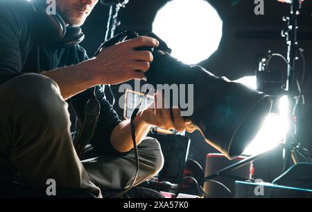 Un photographe avec un appareil photo contre les lumières floues en arrière-plan Banque D'Images