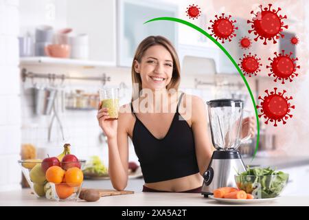 Femme heureuse avec cocktail stimulant l'immunité dans la cuisine. Protection contre les virus Banque D'Images