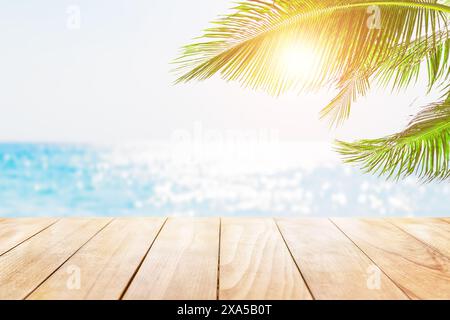 Vieille table en bois avec de l'eau turquoise, des feuilles de palmier de noix de coco et fond de ciel bleu. Vierge prêt à monter l'écran de votre produit. Banque D'Images