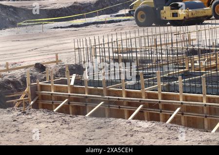 Un chantier de construction avec machines et échafaudage en bois Banque D'Images