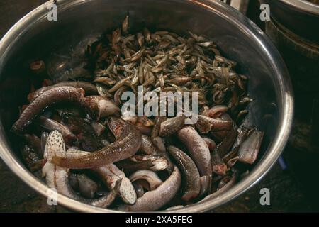Un bol en métal rempli de fruits de mer crus frais dans le marché humide traditionnel local Samaki à Kampot Cambodge Banque D'Images