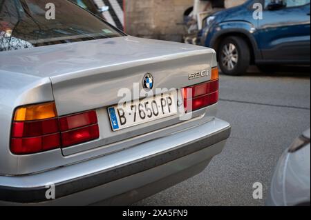 Une vieille BMW série 520i 5 génération E34 en couleur argent garée dans la rue de la ville de Barcelone Banque D'Images