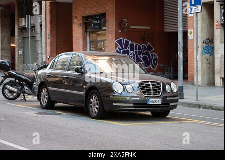 Un véhicule Kia Opirus de couleur foncée stationné dans les rues de la ville de Barcelone Banque D'Images