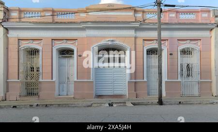 351 Maison rose construite en 1928 dans un style éclectique, restaurée à nouveau avec ses moulures d'origine ainsi qu'une porte de garage moderne. Camaguey-Cuba. Banque D'Images