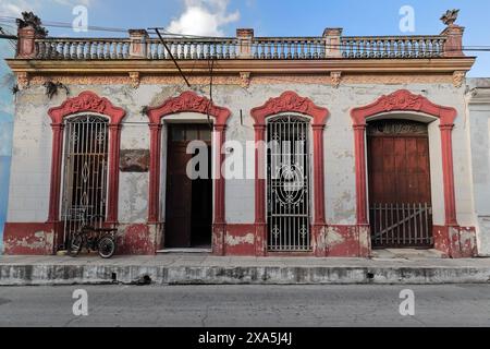 352 Maison blanche et rouge du début des années 1900 dans un style éclectique, restaurée mais ébréchée, appartenant au secteur de la culture municipale. Camaguey-Cuba. Banque D'Images