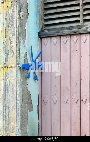 354 ciseaux et peigne découpés dans une plaque de polystyrène expansé et peints en bleu, symbole d'un salon de coiffure dans le quartier du centre historique. Camaguey-Cuba. Banque D'Images