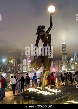 Vue de la statue des Hong Kong film Awards debout sur l'avenue des étoiles de Hong Kong sur le front de mer de Kowloon illuminée la nuit Banque D'Images