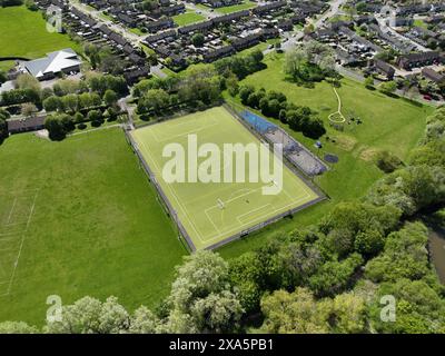 Une vue aérienne d'un terrain de football vert entouré d'un champ et de maisons. Banque D'Images